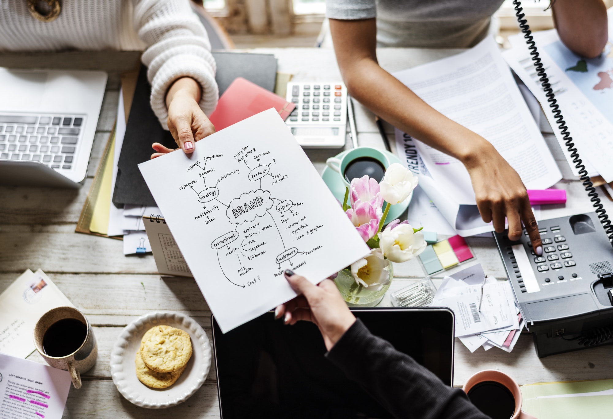colleagues handing branding plan strategy to other.jpg